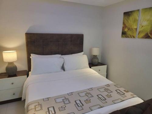 a bedroom with a large white bed with two lamps at Sheryll Escapes - 214 La Grande Studio, comfy hotel amenities with Netflix! in Angeles