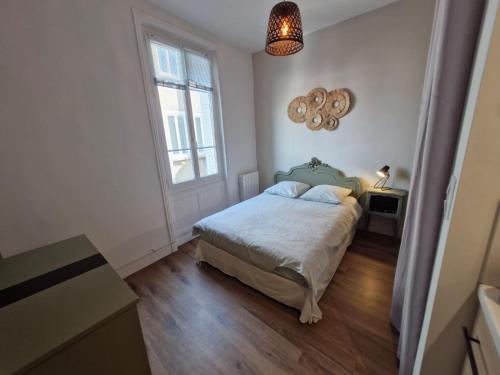 ein weißes Schlafzimmer mit einem Bett und einem Fenster in der Unterkunft Promenades / 1 Chambre / Neuf in Roanne