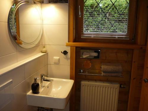 ein Bad mit einem Waschbecken, einem Spiegel und einem Fenster in der Unterkunft Am Schlierbach in Unterwössen