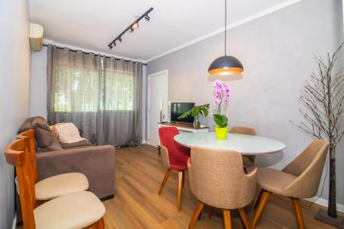 a living room with a table and chairs and a couch at APTO 2 DORM PRÓXIMO CONSULADO AMERICANO, FIERGS, C0MPLETO E GARAGEM in Porto Alegre