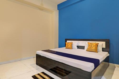 Schlafzimmer mit einem Bett mit blauer Wand in der Unterkunft SPOT ON 81363 Ak Hotel 