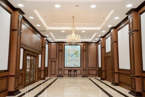 an empty hallway with wood paneling and a chandelier at Ngoc Thu Palace in Soc Trang