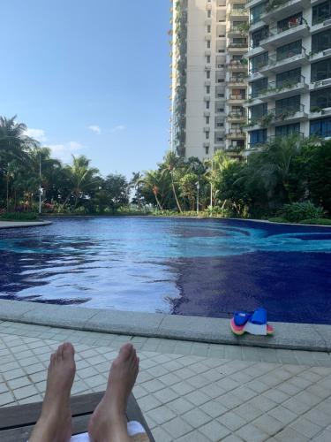 a person laying on the edge of a swimming pool at Colorful Seaview apartment Forestcity Johor Bahru Malaysia in Gelang Patah