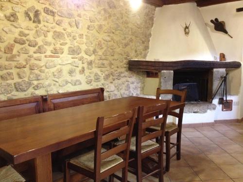 een eetkamer met een houten tafel en een open haard bij Casa Vacanze Sotto l'Arco in Barete