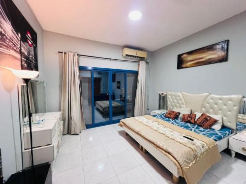 a bedroom with a bed and a large window at Studio Apartment in Ajman 