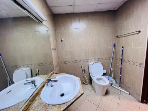 a bathroom with a sink and a toilet at Studio Apartment in Ajman 