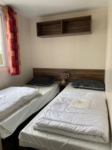 deux lits jumeaux dans une chambre avec fenêtre dans l'établissement Mobile home Cc995 near swimming pool - Les Charmettes, aux Mathes
