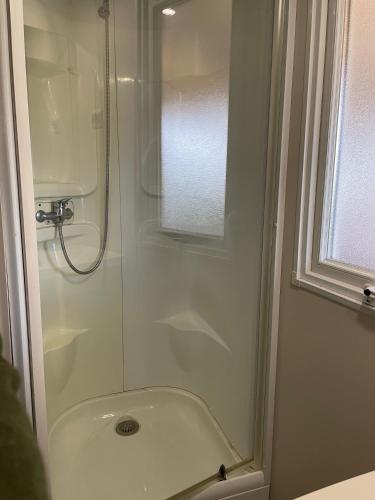 une salle de bain avec une douche avec une porte vitrée dans l'établissement Mobile home Cc995 near swimming pool - Les Charmettes, aux Mathes