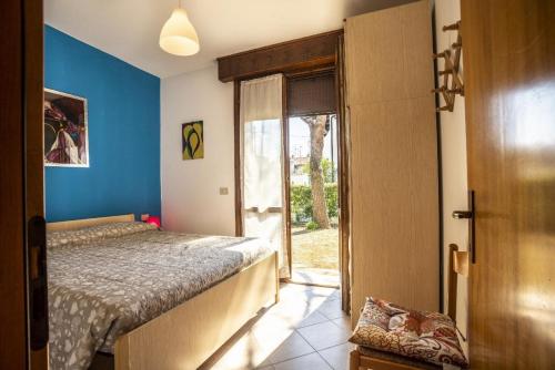 a bedroom with a bed and a door to a window at Ferienhaus in Lido Di Volano mit Terrasse, Grill und Garten in Lido di Volano