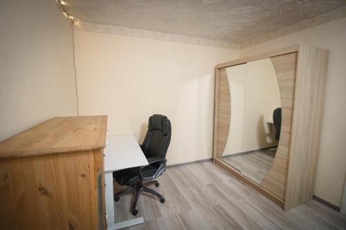 een kantoor met een spiegel, een bureau en stoelen bij Anne Apartment - 1 Bedroom + Balcony in Tartu