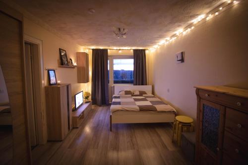 een slaapkamer met een bed en een raam met verlichting bij Anne Apartment - 1 Bedroom + Balcony in Tartu