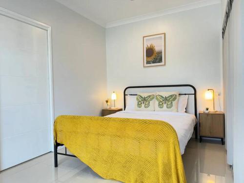 a bedroom with a bed with a yellow blanket on it at Convenient 2 Bedroom house unit in Salisbury in Brisbane