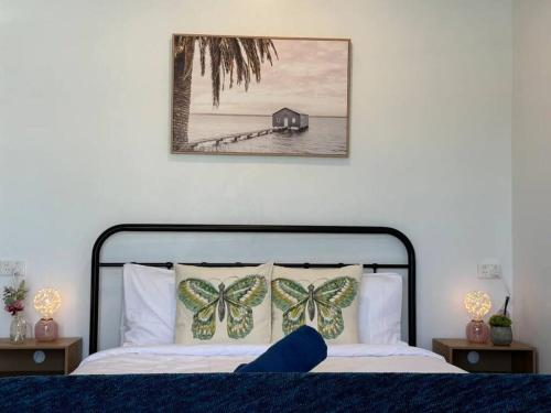 a bedroom with a bed with butterflies on the pillows at Convenient 2 Bedroom house unit in Salisbury in Brisbane