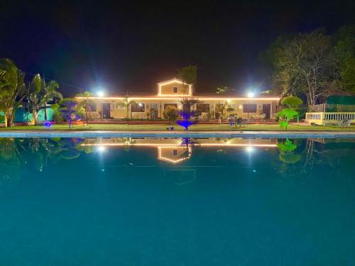 a house with a swimming pool at night at Vanzara Retreat in Gurgaon