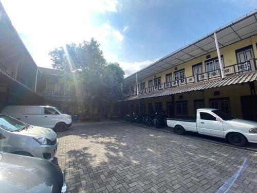 a group of vehicles parked in front of a building at Jogja Inn in Timuran