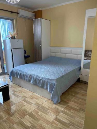 1 dormitorio con 1 cama y nevera en Квартира на пляже, en Durrës