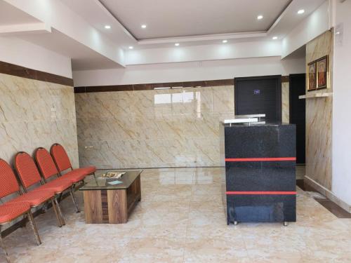 una sala d'attesa con sedie rosse e un tavolo di Royal Residency a Rāmanagaram