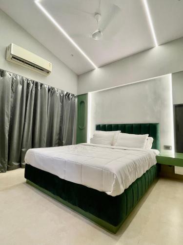 a bedroom with a large bed with a green headboard at Dreamview Mountains - Cozy 1bhk with Sunrise view in Karjat