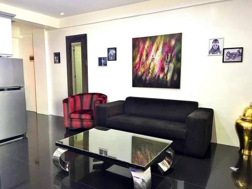 a living room with a couch and a coffee table at Sheryll Escapes - Kandi luxury 1BR, housekeeping & Netflix! in Angeles