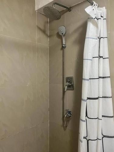 a shower in a bathroom with a shower curtain at Sheryll Escapes - Kandi luxury 1BR, housekeeping & Netflix! in Angeles