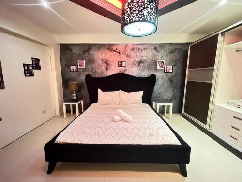 a bedroom with a large bed with pink sheets at Sheryll Escapes - Kandi luxury 1BR, housekeeping & Netflix! in Angeles