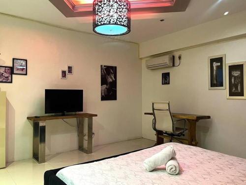 a bedroom with a bed and a desk and a television at Sheryll Escapes - Kandi luxury 1BR, housekeeping & Netflix! in Angeles