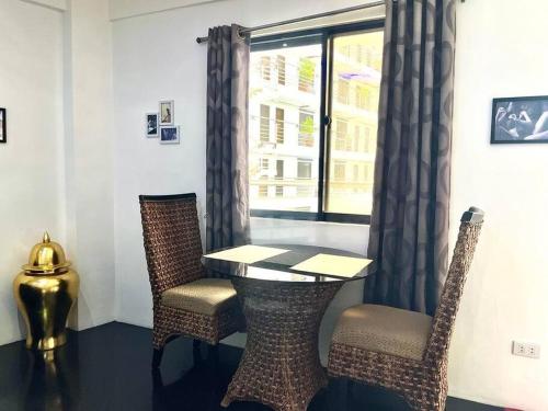 a table and chairs in a room with a window at Sheryll Escapes - Kandi luxury 1BR, housekeeping & Netflix! in Angeles