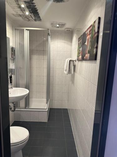 a bathroom with a shower and a toilet and a sink at Friesdorfer Hof in Bonn