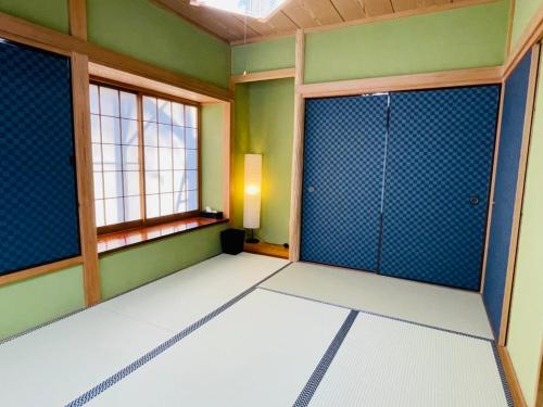 伊東市にあるJ-HOUSEの緑の壁と窓が特徴の空間