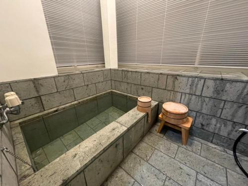 伊東市にあるJ-HOUSEのバスタブ、トイレ、スツールが備わります。