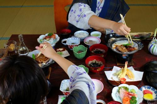 un grupo de niños comiendo comida en una mesa en Shinzanso, en Takayama