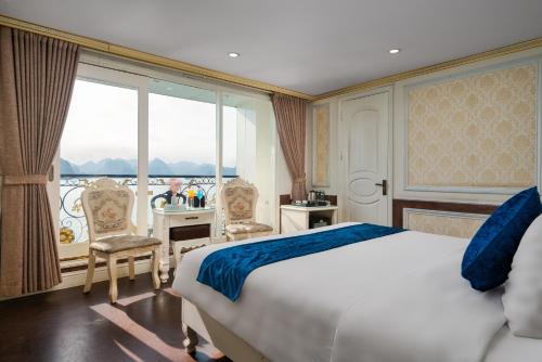 ein Schlafzimmer mit einem Bett und einem großen Fenster in der Unterkunft Hạ Long Aqua Legend Cruise in Hạ Long