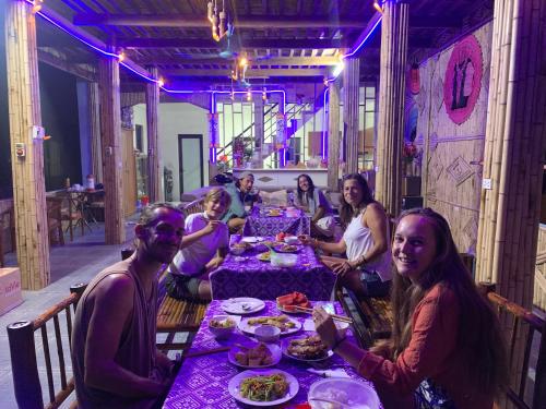 a group of women sitting at a table with a purple table at Mai chau Horizon Homestay in Mai Chau