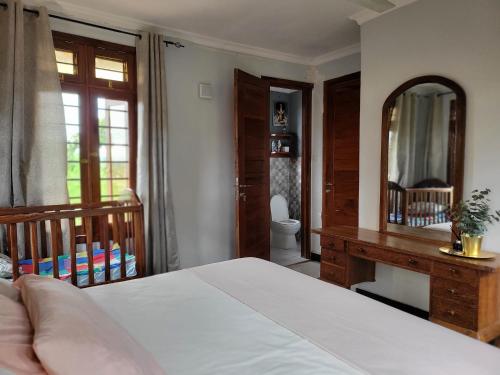 a bedroom with a bed and a desk and a mirror at Funvilla Family House in Dar es Salaam