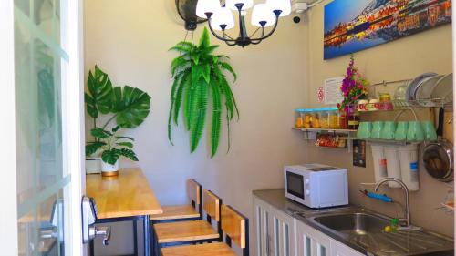 a kitchen with a sink and a counter with a microwave at Fall Asleep hotel in Nonthaburi