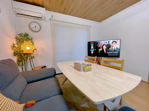 uma sala de estar com uma mesa e uma televisão em ヴィラ山間堂 Terrace Villa BBQ Bonfire Fuji view Annovillas em Fujikawaguchiko