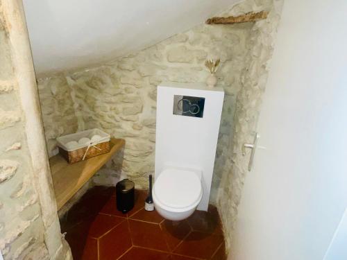 a bathroom with a toilet in a stone wall at Maisonette duplex - Tout equipé - Matelas haute qualité in Marly-le-Roi