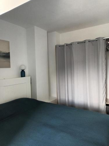 - une chambre avec un lit et un rideau dans l'établissement T2 Cozy Rungis - 15min de Paris !, à Rungis