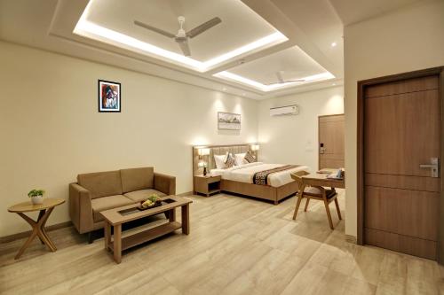 a living room with a bed and a couch and a room at Hotel AMBS suites A family Hotel Near Delhi Airport in New Delhi