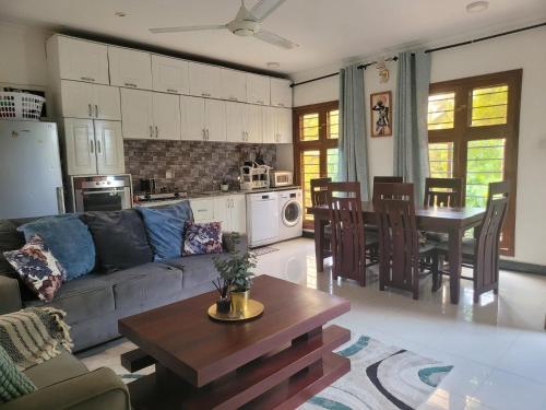 ein Wohnzimmer mit einem Sofa und einem Tisch in der Unterkunft Funvilla Family House in Daressalam