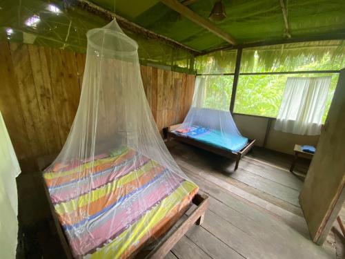 una habitación con una cama y una red en ella en Buchisapa Lodge, en Iquitos