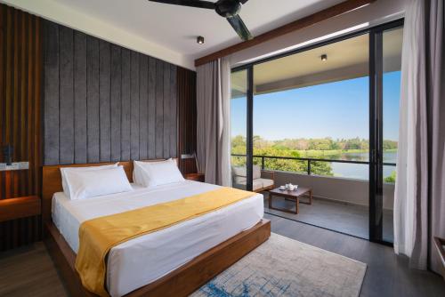 1 dormitorio con cama grande y ventana grande en Thimbiri Wewa Resort Wilpattu, en Wilpattu