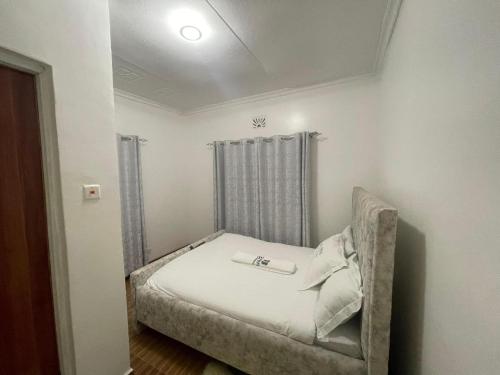 małą sypialnię z łóżkiem w pokoju w obiekcie SERENE GUEST HOUSE w mieście Eldoret