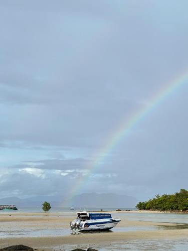 a boat sitting on the sand on a beach at Hillhouse - Koh Yao Noi in Ko Yao Noi
