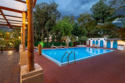 a swimming pool in a yard with a building at Lutyens Bungalow in New Delhi