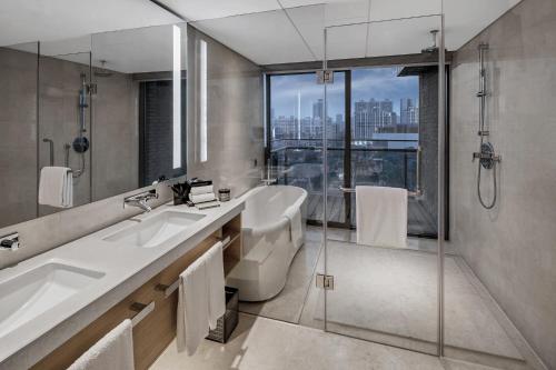 La salle de bains est pourvue de 2 lavabos et d'une douche. dans l'établissement Cordis, Foshan, Lingnan Tiandi-Canton Fair free shuttle bus, à Foshan