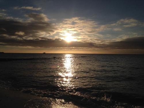 a sunset over the ocean with the sun setting at Hotel Skovly in Rønne