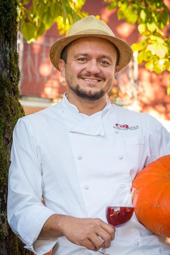 a man in a hat holding a glass of wine at Gasthof Post in Sankt Gallen