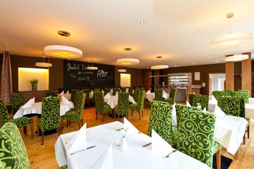 a restaurant with white tables and green chairs at Gasthof Post in Sankt Gallen
