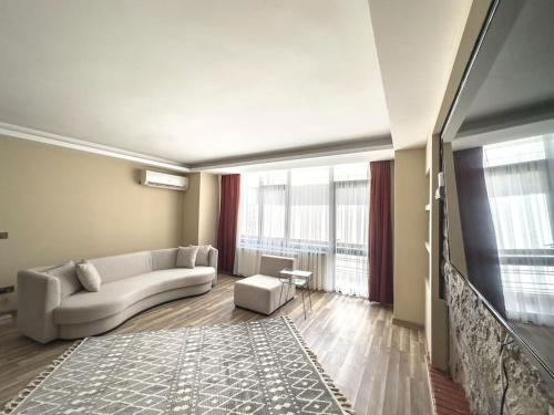 ein Wohnzimmer mit einem weißen Sofa und einem großen Fenster in der Unterkunft 110-Peaceful in Ankara